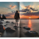 Hajtogatott kép 02 - Naplementés tengerparton egy férfi áll egy tengerből kiemelkedő alacsony sziklán.