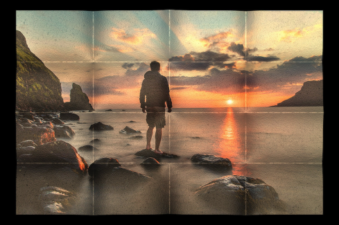 Hajtogatott kép 05 - Naplementés tengerparton egy férfi áll egy tengerből kiemelkedő alacsony sziklán.