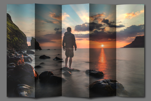 Hajtogatott kép 17 - Naplementés tengerparton egy férfi áll egy tengerből kiemelkedő alacsony sziklán.
