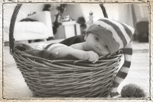 Baba fotó retusálás 06 - Két alvó újszülött baba összebújva egy szőrmével kibélelt kosárban egy vékony takaróval betakarva.